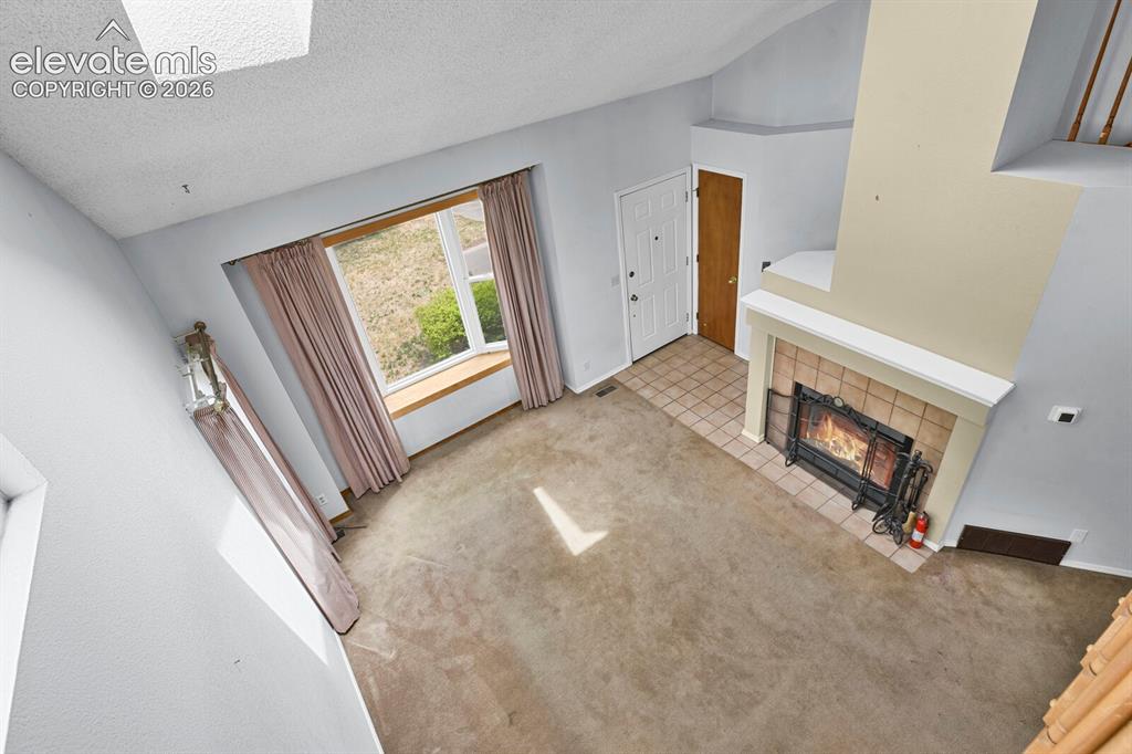 Image 47 of 48: Living area featuring a floor-to-ceiling fireplace with a tile surround and