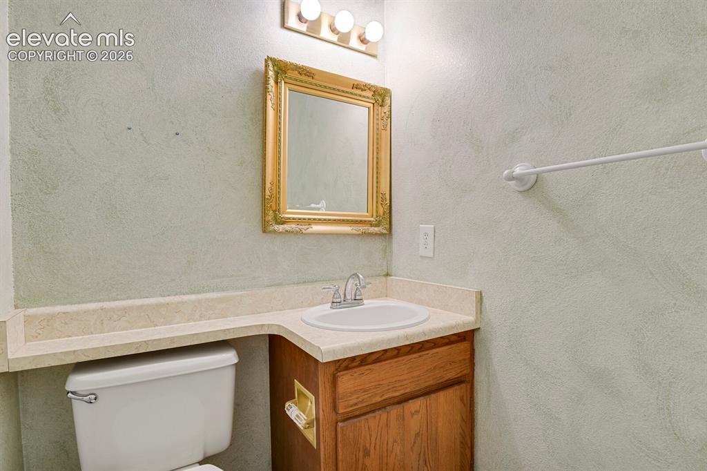 Image 9 of 48: Bathroom featuring a wood vanity with an integrated sink, a light-toned cou