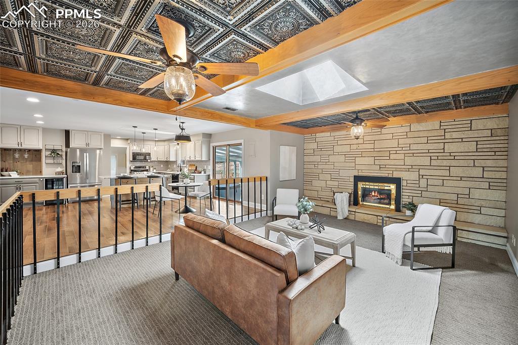 Image 3 of 50: Great room with tin ceiling and beautiful fireplace.