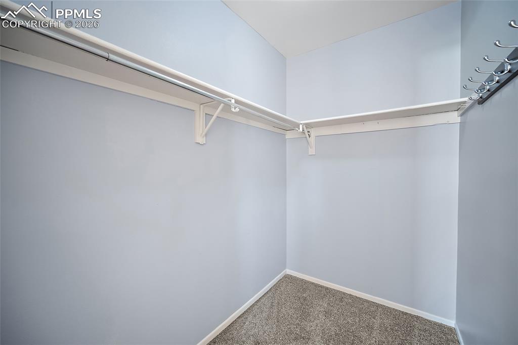 Image 31 of 50: Walk-in closet off primary bedroom.