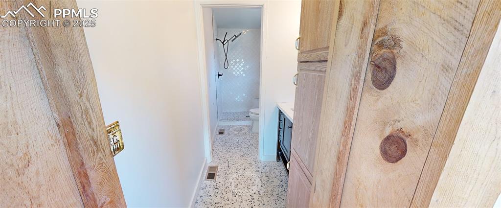 Image 5 of 23: Back of house with a patio, a wooden deck, a metal roof, and an attached ga