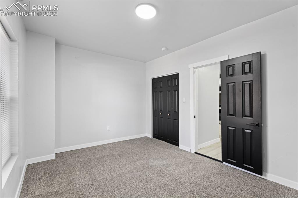 Image 13 of 32: Unfurnished bedroom with light colored carpet and a closet