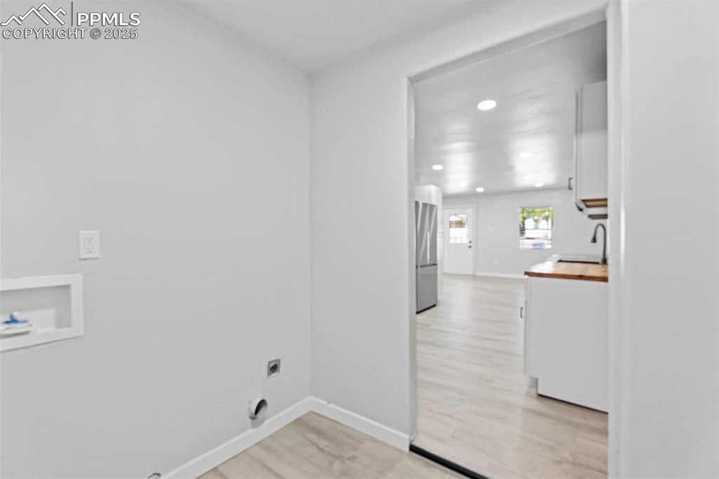 Image 14 of 32: Washroom featuring light wood-style flooring, washer hookup, recessed light