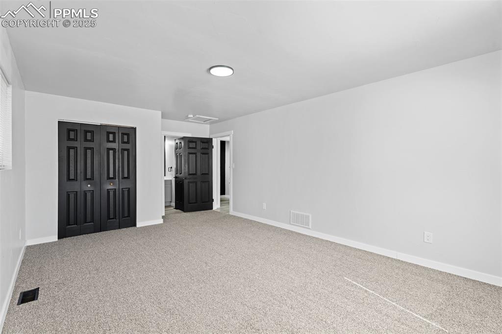 Image 19 of 32: Unfurnished bedroom featuring attic access, carpet, and a closet
