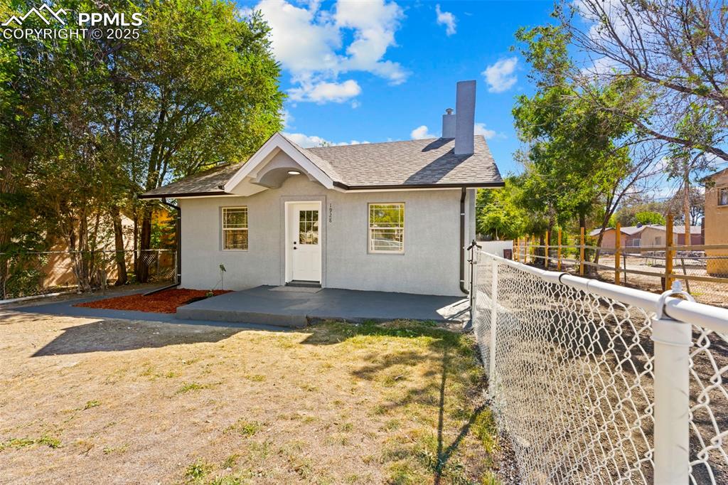 Image 2 of 32: View of front facade featuring a fenced backyard, roof with shingles, a chi