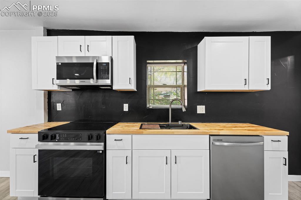 Image 21 of 32: Kitchen featuring light wood-style flooring, appliances with stainless stee