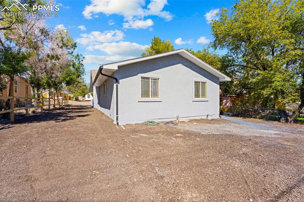 Image 30 of 32: View of side of property featuring stucco siding