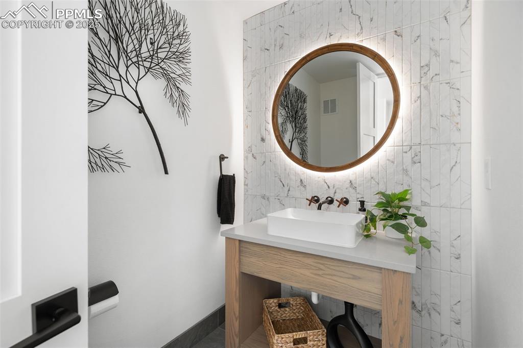 Image 18 of 50: Main Level Powder Room with custom made back-lit mirror and custom wall mou