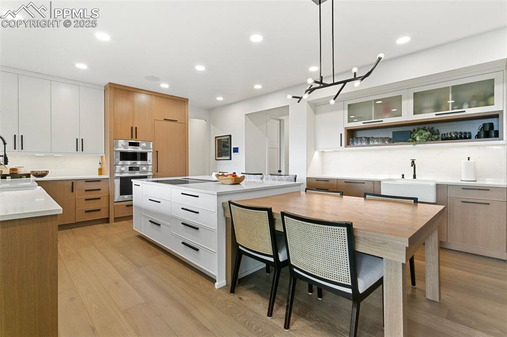 Image 9 of 50: The grand kitchen island provides an abundance of storage, a built-in white