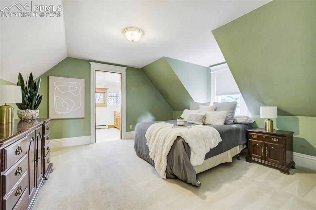 Image 23 of 50: Spacious primary bedroom maintains charm of the time period