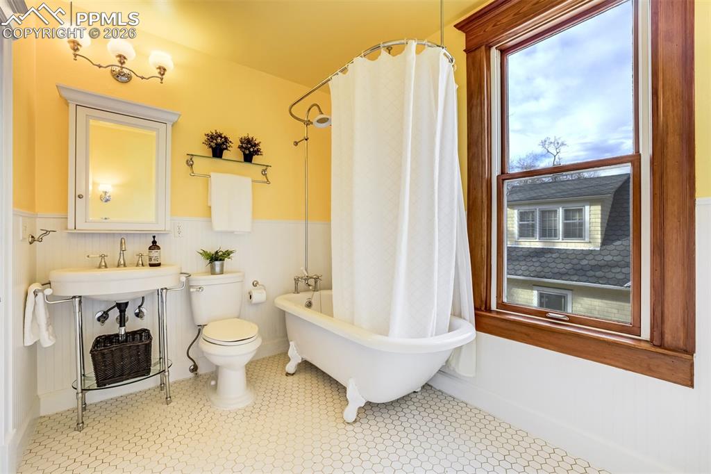 Image 34 of 50: Full bathroom upstairs features a charming claw foot tub!