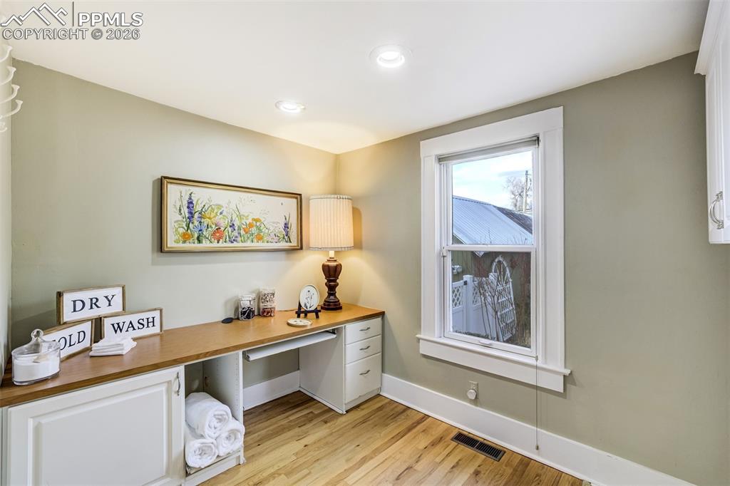 Image 37 of 50: Large main level laundry room features space for office and crafts
