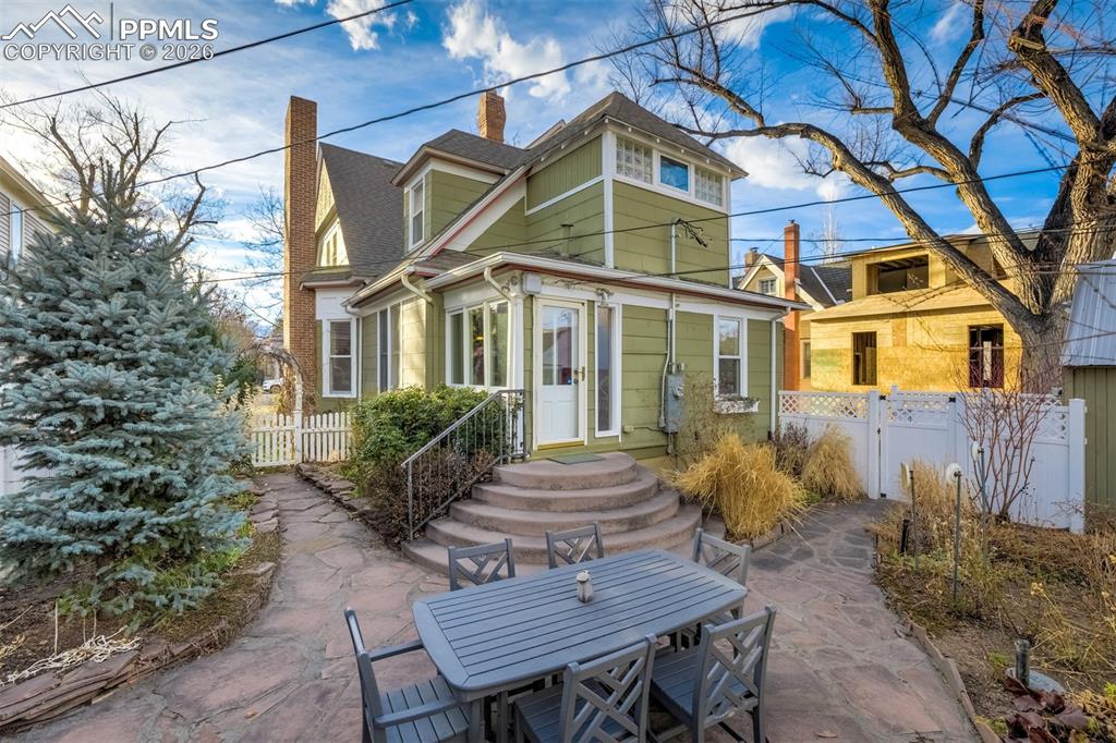 Image 42 of 50: Back of home leads to this charming patio