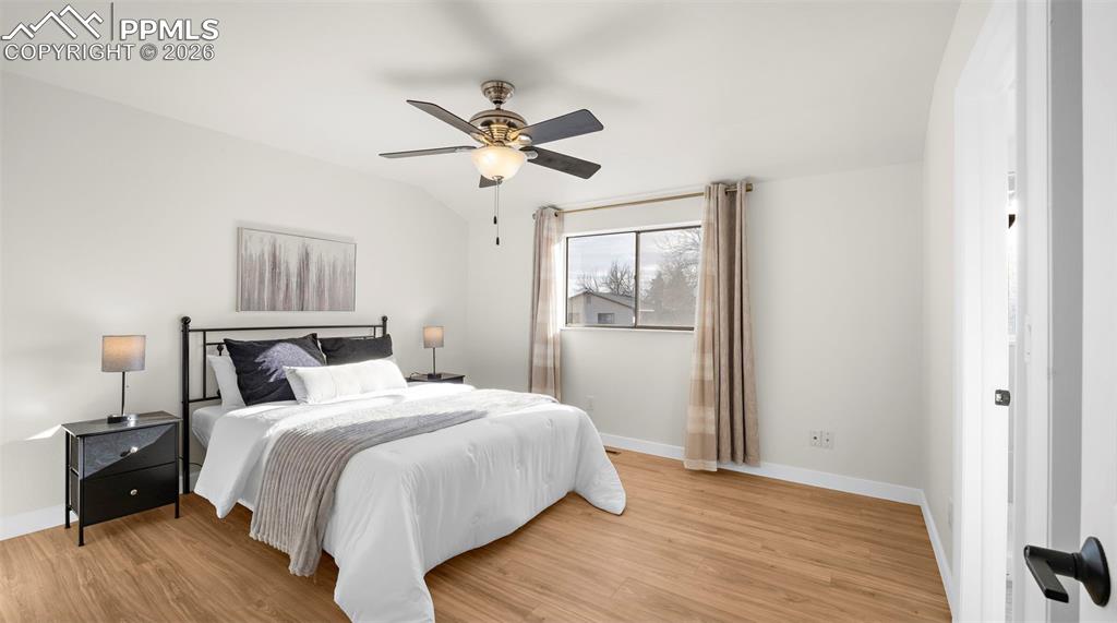 Image 13 of 32: Bedroom featuring light wood finished floors, ceiling fan, and lofted ceili