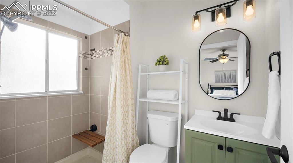 Image 17 of 32: Full bathroom with vanity, a shower stall, and ceiling fan