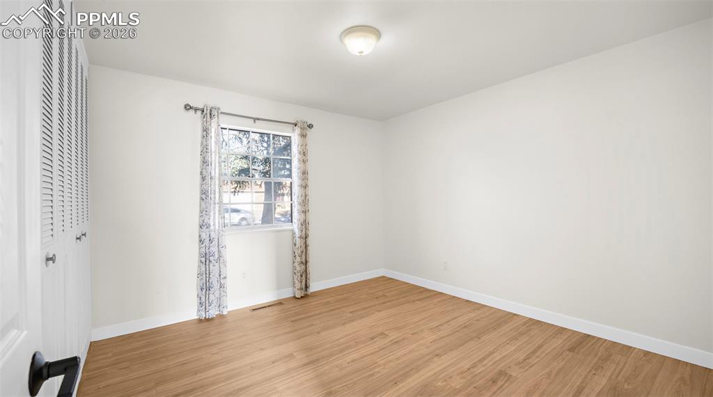 Image 18 of 32: Spare room with baseboards and light wood-style floors