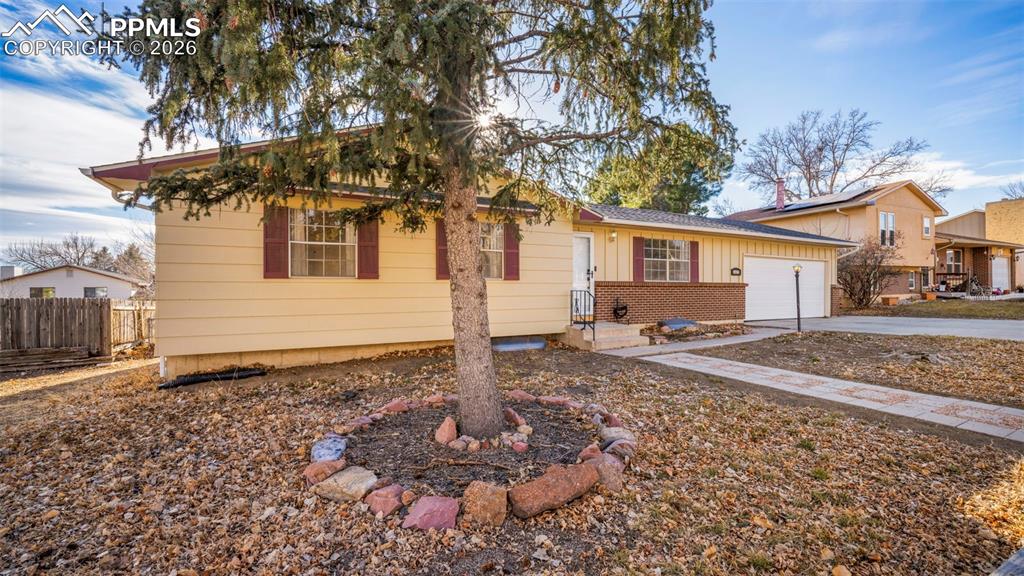 Image 2 of 32: Single story home featuring a garage, board and batten siding, brick siding
