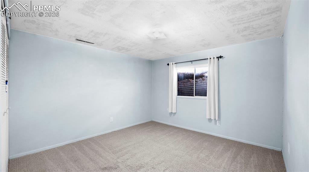Image 26 of 32: Unfurnished room featuring carpet and baseboards
