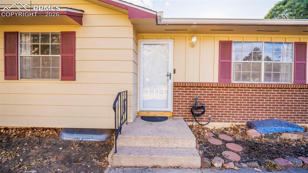 Image 28 of 32: Property entrance with board and batten siding