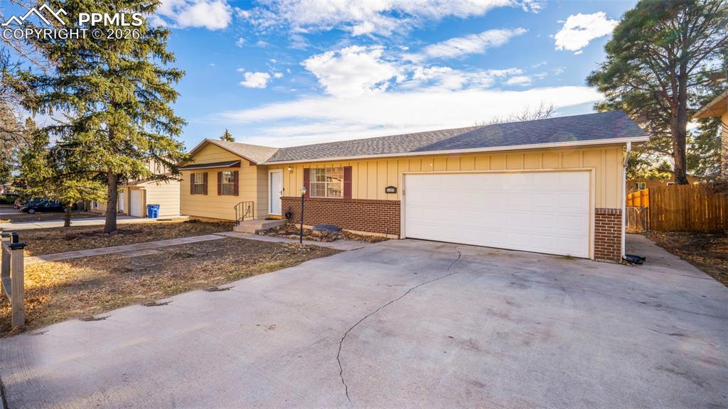 Image 3 of 32: Ranch-style house featuring board and batten siding, brick siding, and driv