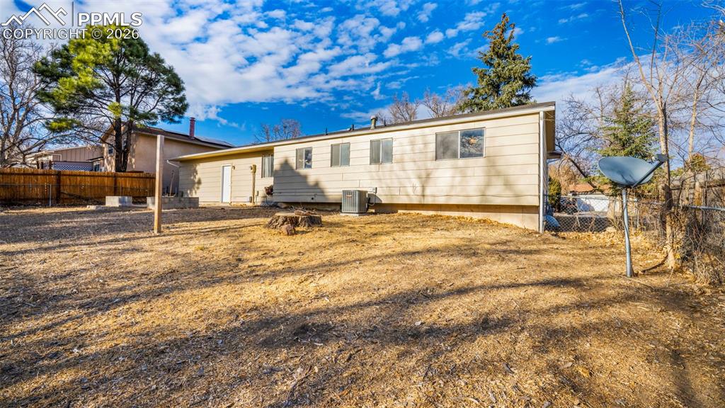 Image 30 of 32: Rear view of house with a fenced backyard