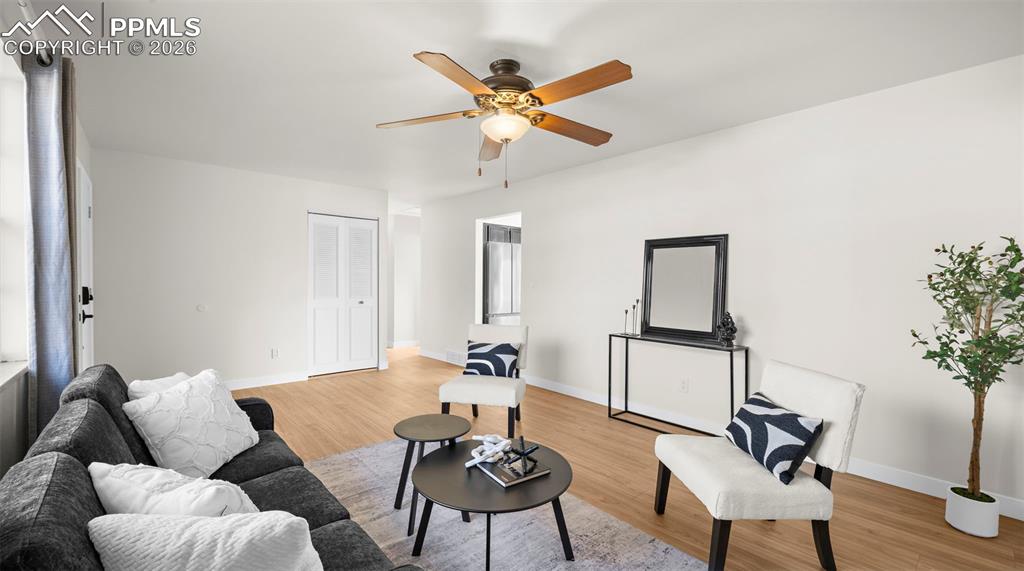 Image 6 of 32: Living room with light wood-style floors and a ceiling fan