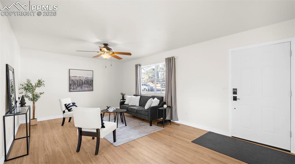Image 7 of 32: Living area featuring a ceiling fan and light wood finished floors