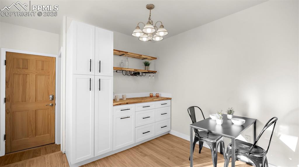 Image 8 of 32: Dining area featuring suspended lighting and light wood finished floors