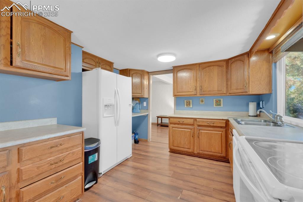 Image 16 of 32: Kitchen with light countertops, white appliances, and light wood-type floor