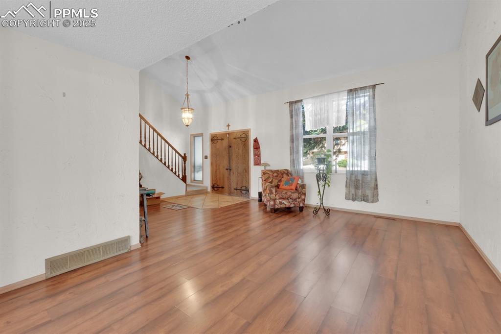 Image 9 of 32: Entry off living area with stairs leading to upper level