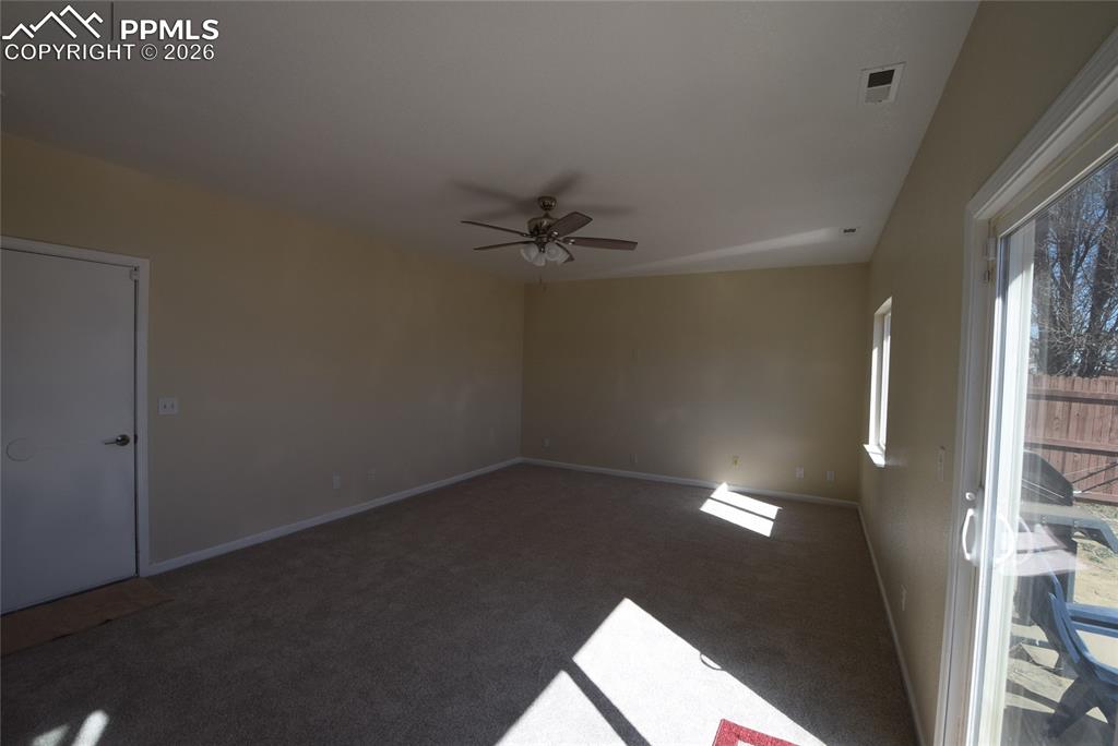 Image 15 of 42: The property features a spacious room with carpeting, light-colored walls, 