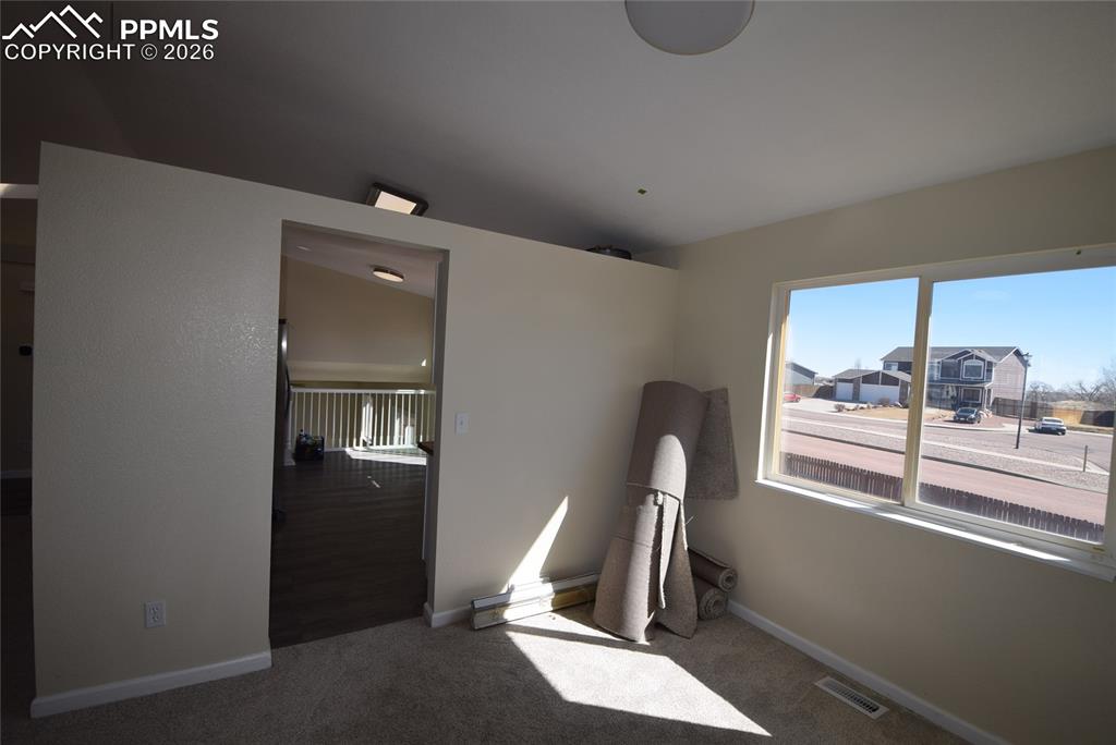 Image 17 of 42: This room features light-colored walls and carpeted flooring