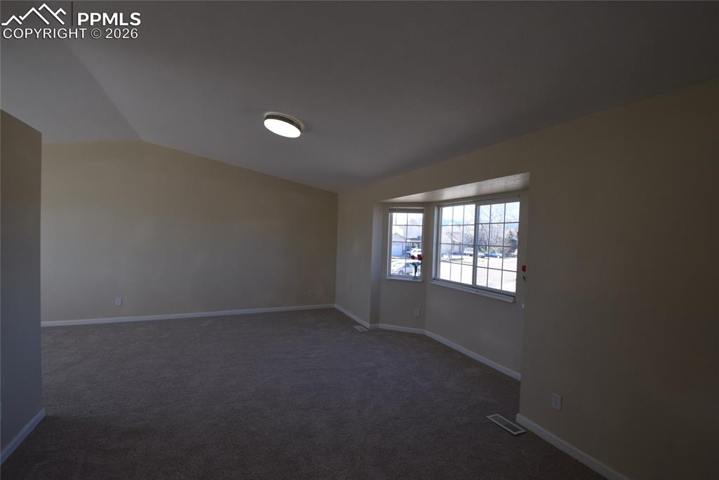 Image 19 of 42: This room features carpeted flooring, light-colored walls, and a bay window