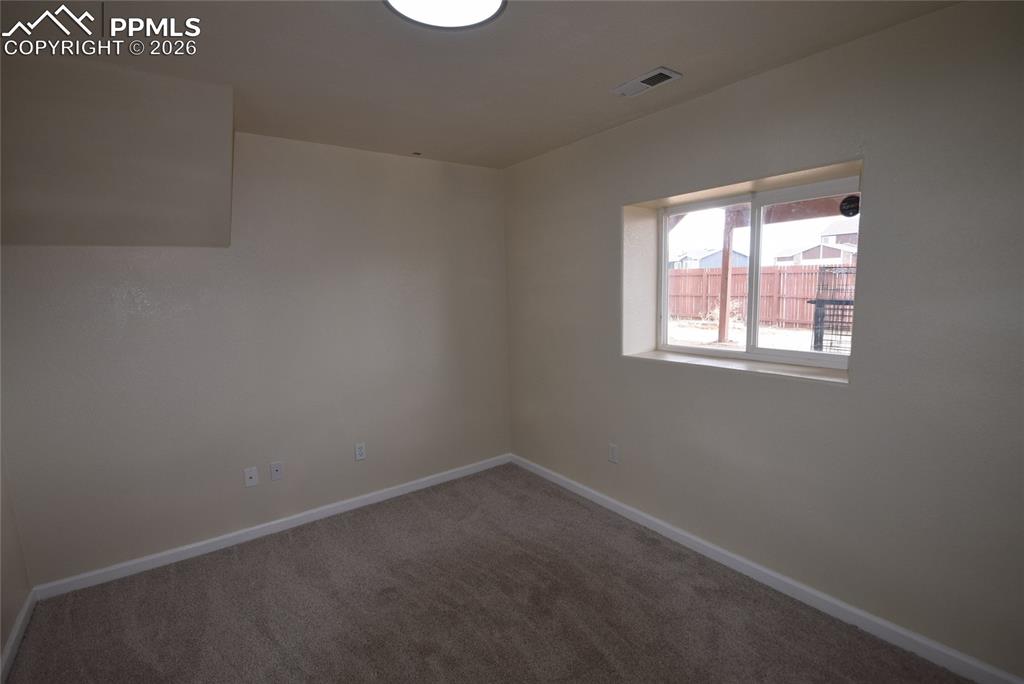 Image 23 of 42: This room features neutral-toned walls, a window providing natural light, a