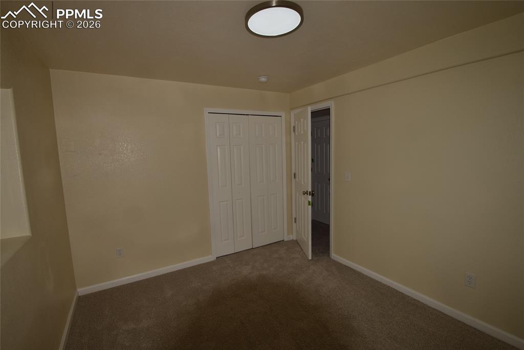 Image 26 of 42: The room features neutral-toned walls, carpeted flooring, a ceiling-mounted