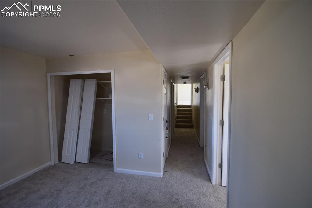 Image 29 of 42: The property features neutral-toned walls, a carpeted floor, and a hallway 