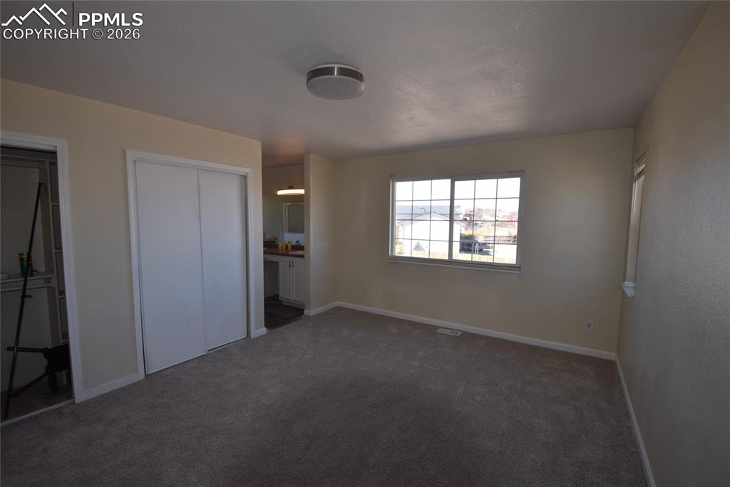 Image 37 of 42: This room features soft gray carpeting, light-colored walls, and a window w