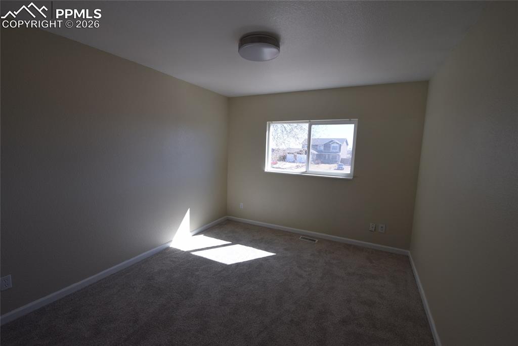 Image 38 of 42: The room features neutral-toned walls, a window providing natural light, an