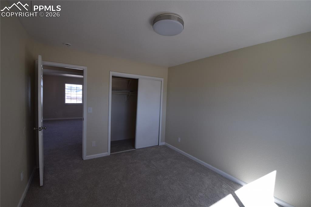 Image 39 of 42: This room features light-colored walls and carpeted flooring, with a ceilin