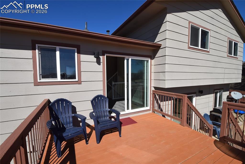 Image 4 of 42: The property features an outdoor deck with wood railings and an exterior do