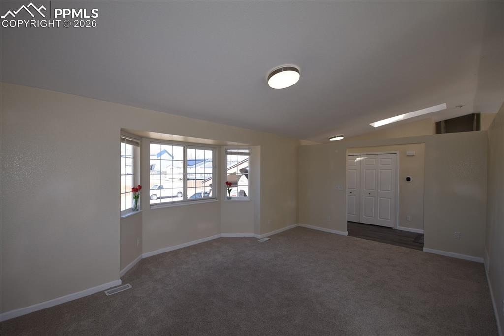 Image 9 of 42: Spacious living area featuring carpeted flooring, bay windows, and recessed