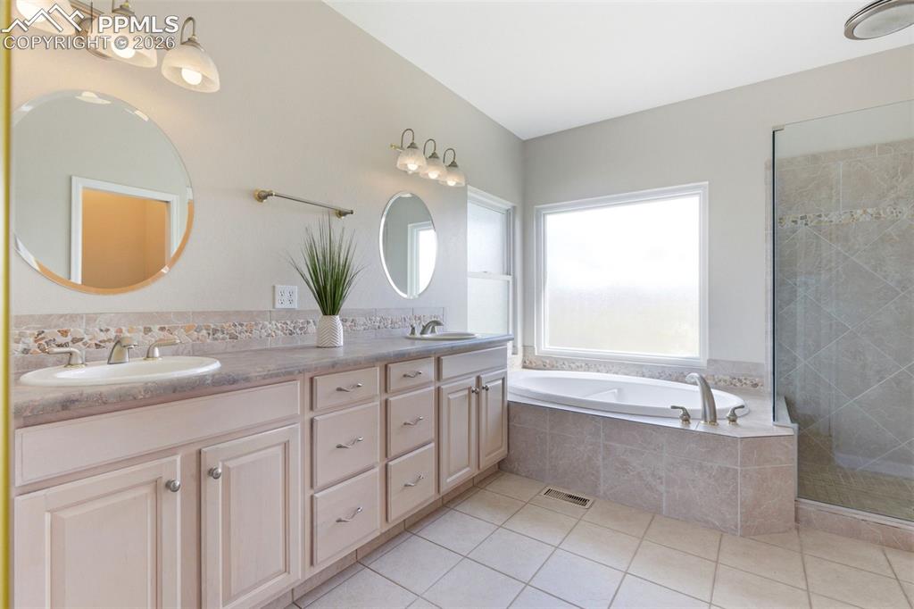 Image 16 of 40: Spacious bathroom featuring a dual vanity with undermount sinks, a built-in
