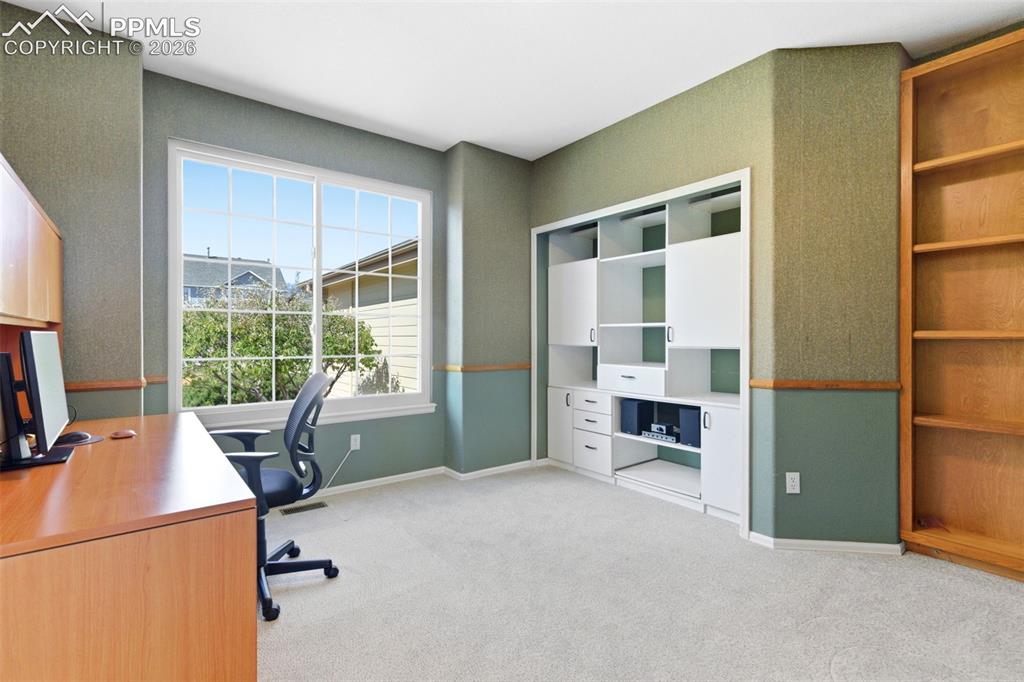 Image 18 of 40: Bright room featuring a large multi-pane window, extensive built-in white c