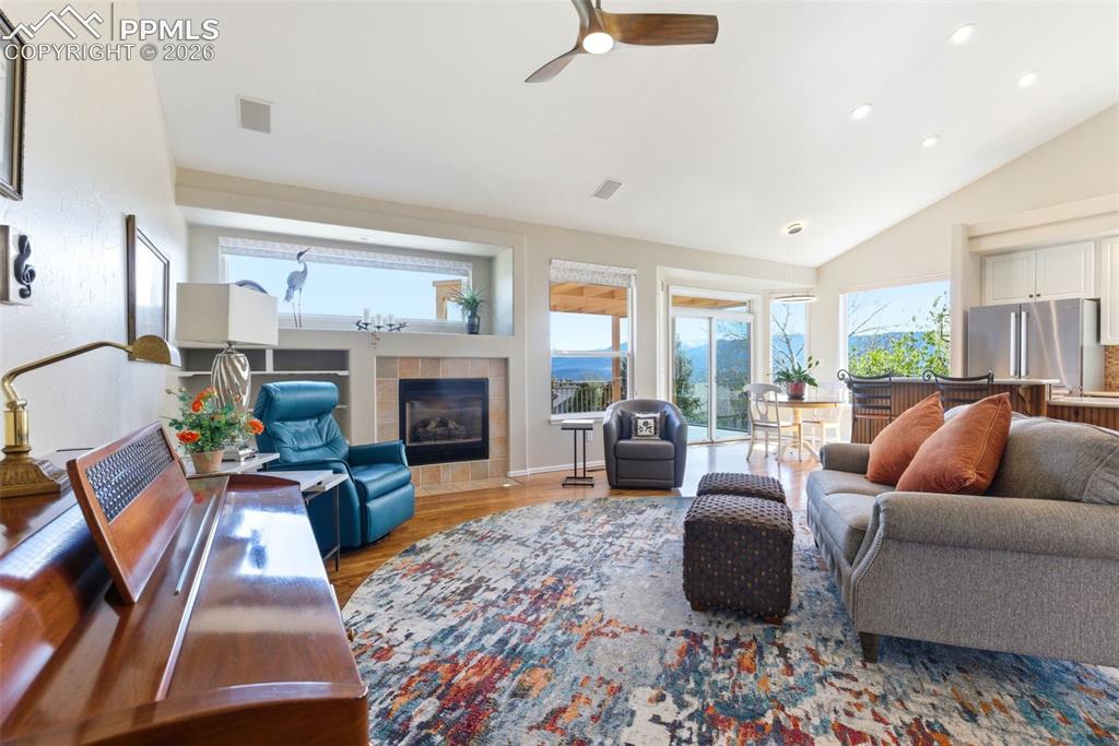 Image 2 of 40: Spacious living area featuring wood-finish flooring, a fireplace with tile