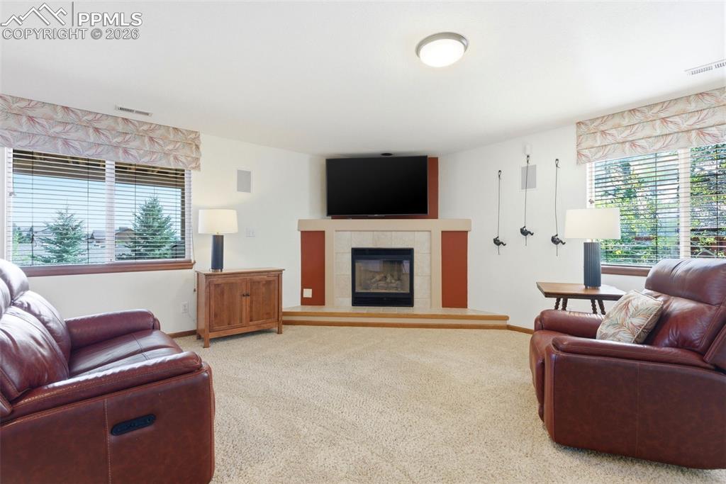 Image 20 of 40: Living area featuring a floor-to-ceiling fireplace with a tile surround and