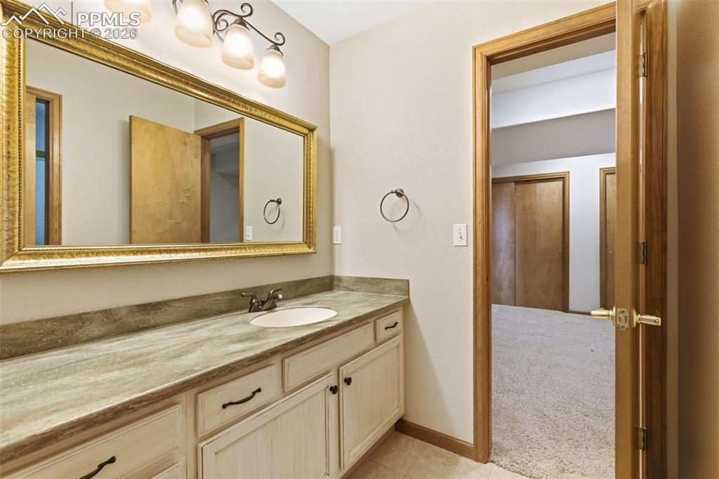 Image 25 of 40: Bathroom vanity featuring a single basin sink, bronze-finish faucet, and an