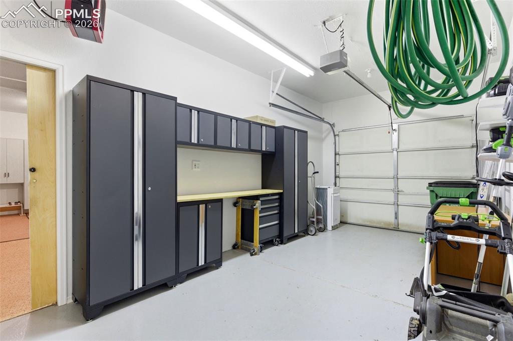 Image 27 of 40: Garage featuring a built-in modular storage system with dark gray cabinetry