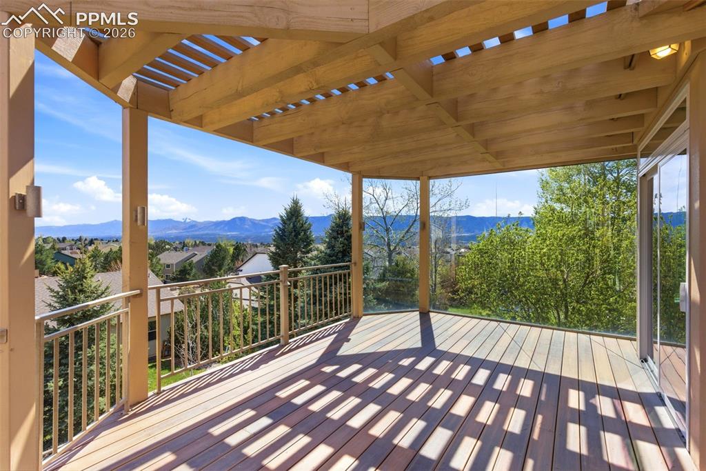 Image 31 of 40: Expansive outdoor deck featuring wood-finish flooring, a slatted wood pergo