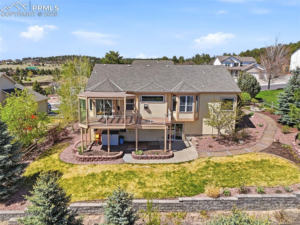 Image 34 of 40: Rear exterior featuring a screened-in porch, open deck, lower-level patio,