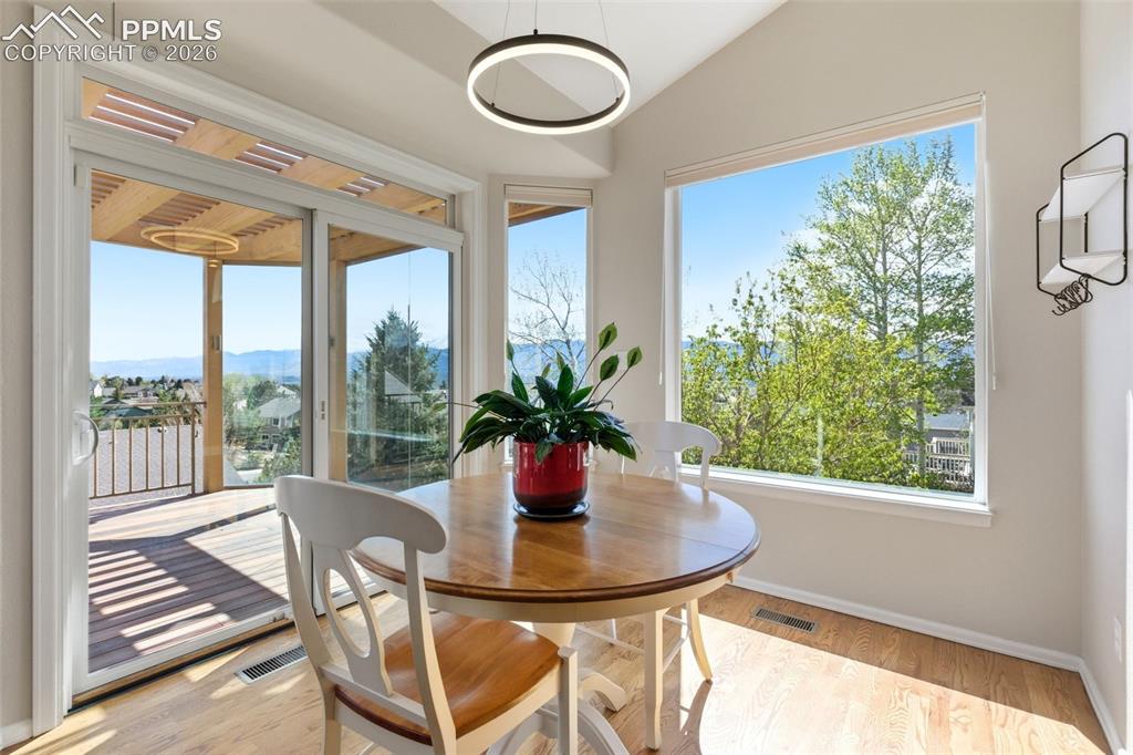 Image 8 of 40: Bright dining area featuring a vaulted ceiling and a contemporary circular